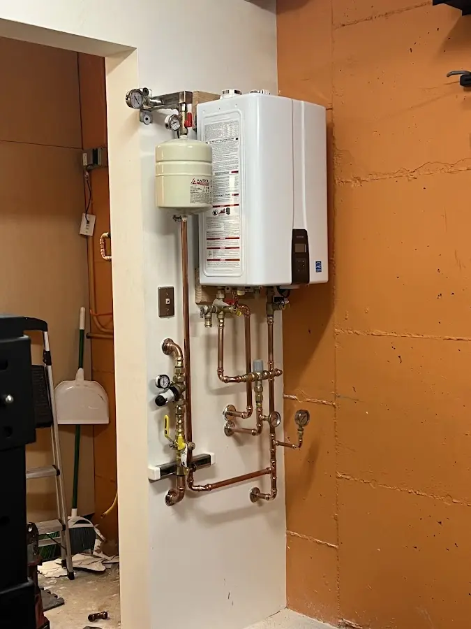 Plumbing technician inspecting water heater connections in Pamelia